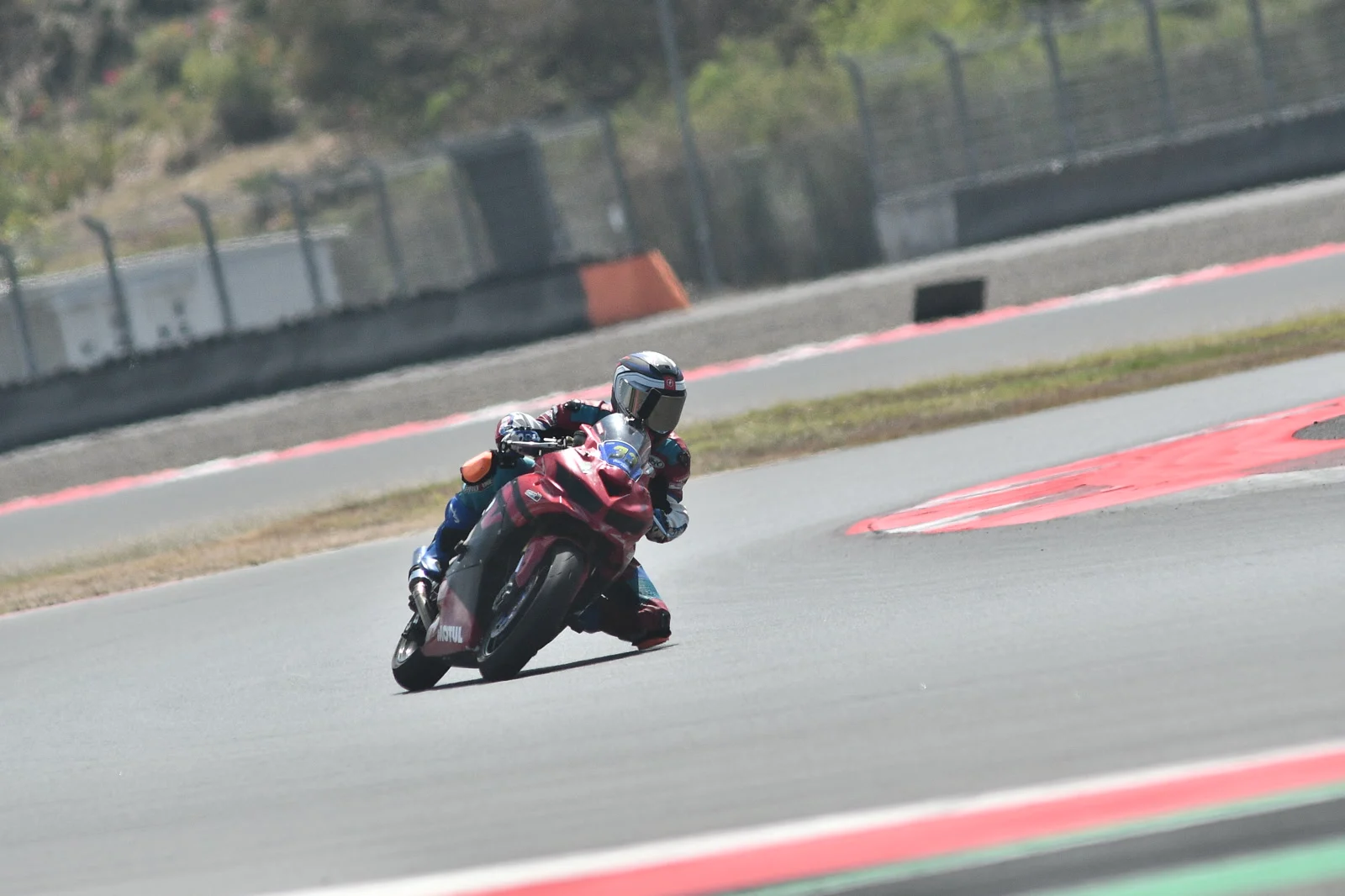 Me with my knee nearly on the ground through a left turn on the red Kawasaki ZX at Mandalika